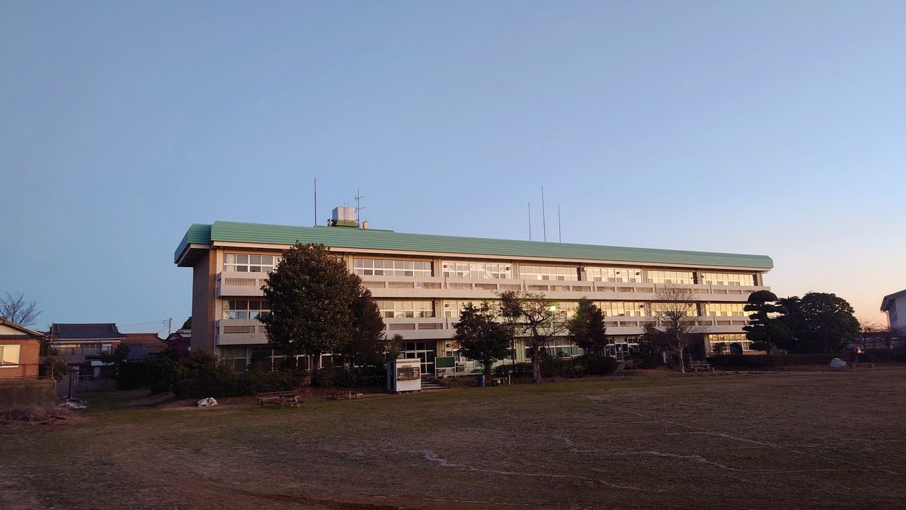 夕暮れの旧石出小学校の校舎と校庭